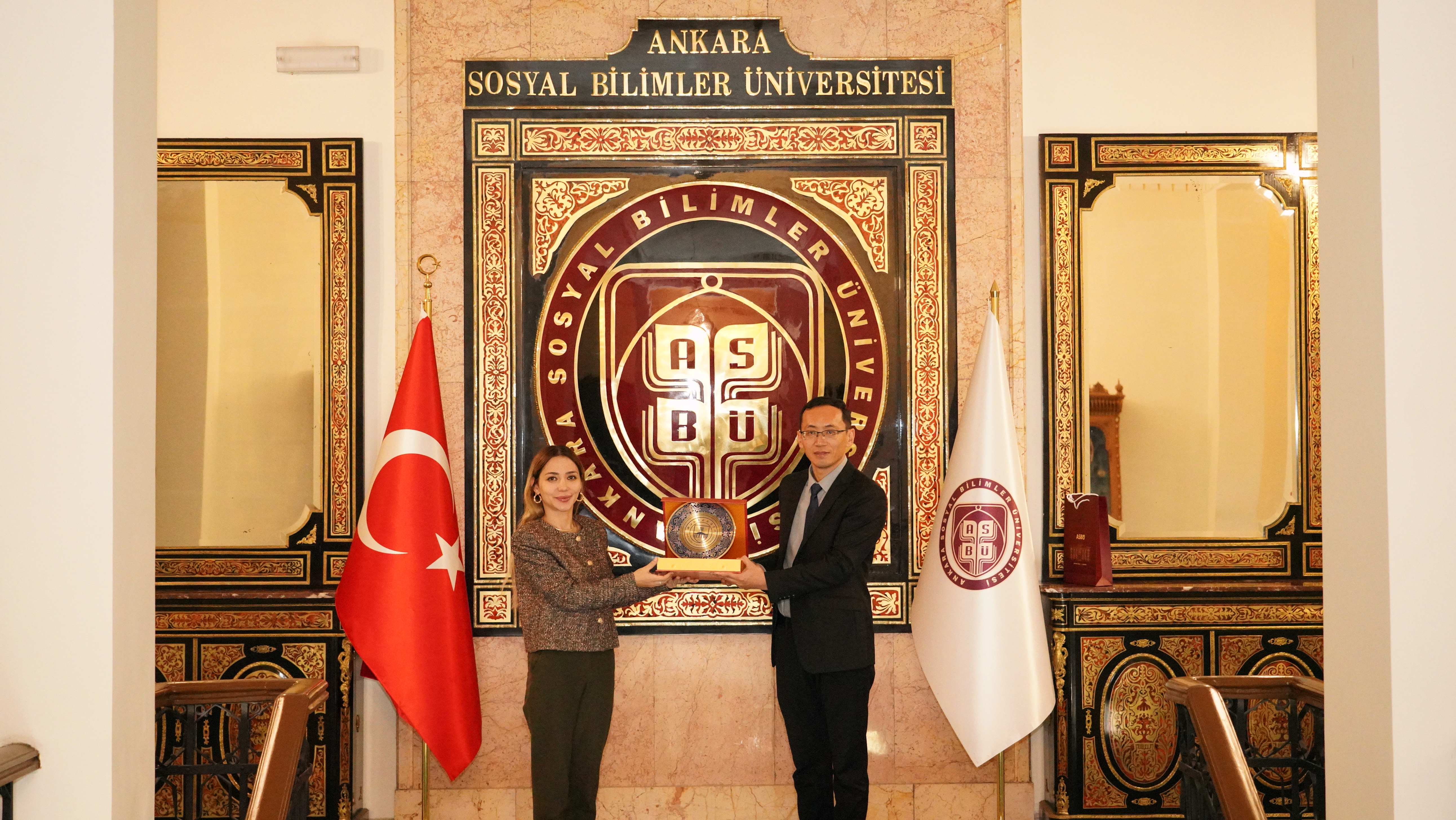  Dr. Öğr. Üyesi Cansu KÖRKEM AKÇAY ve Zhejiang Yuexiu Üniversitesi Doğu Dilleri Fakültesi’nden Dekan Yardımcısı Xıaomıng Ma birbirlerine hediye takdim ediyorlar.