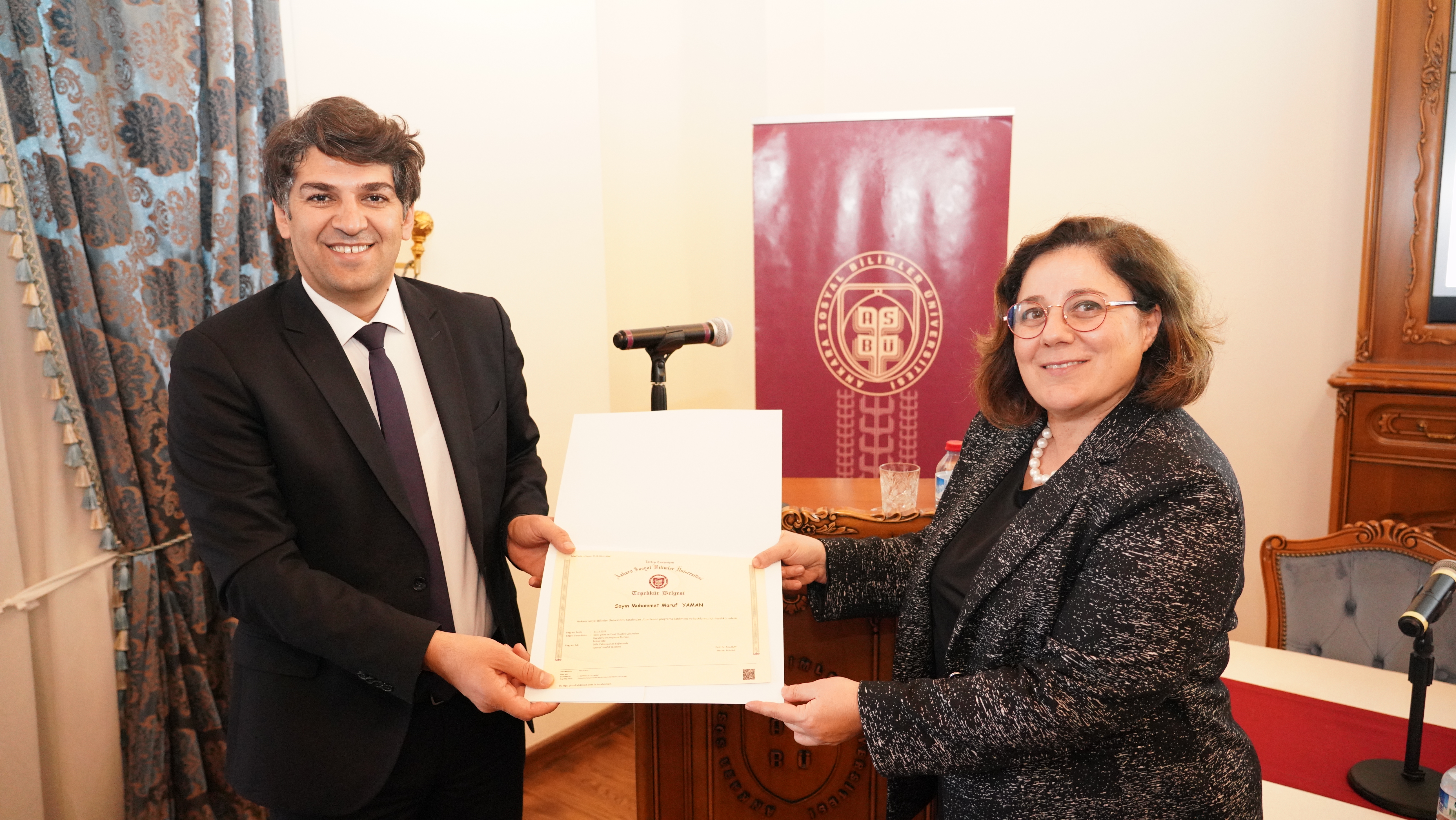 Prof. Dr. Aslı AKAY , AFAD Dış İlişkiler Daire Başkanı Muhammet Maruf Yaman'a Teşekkür belgesini sunuyor.