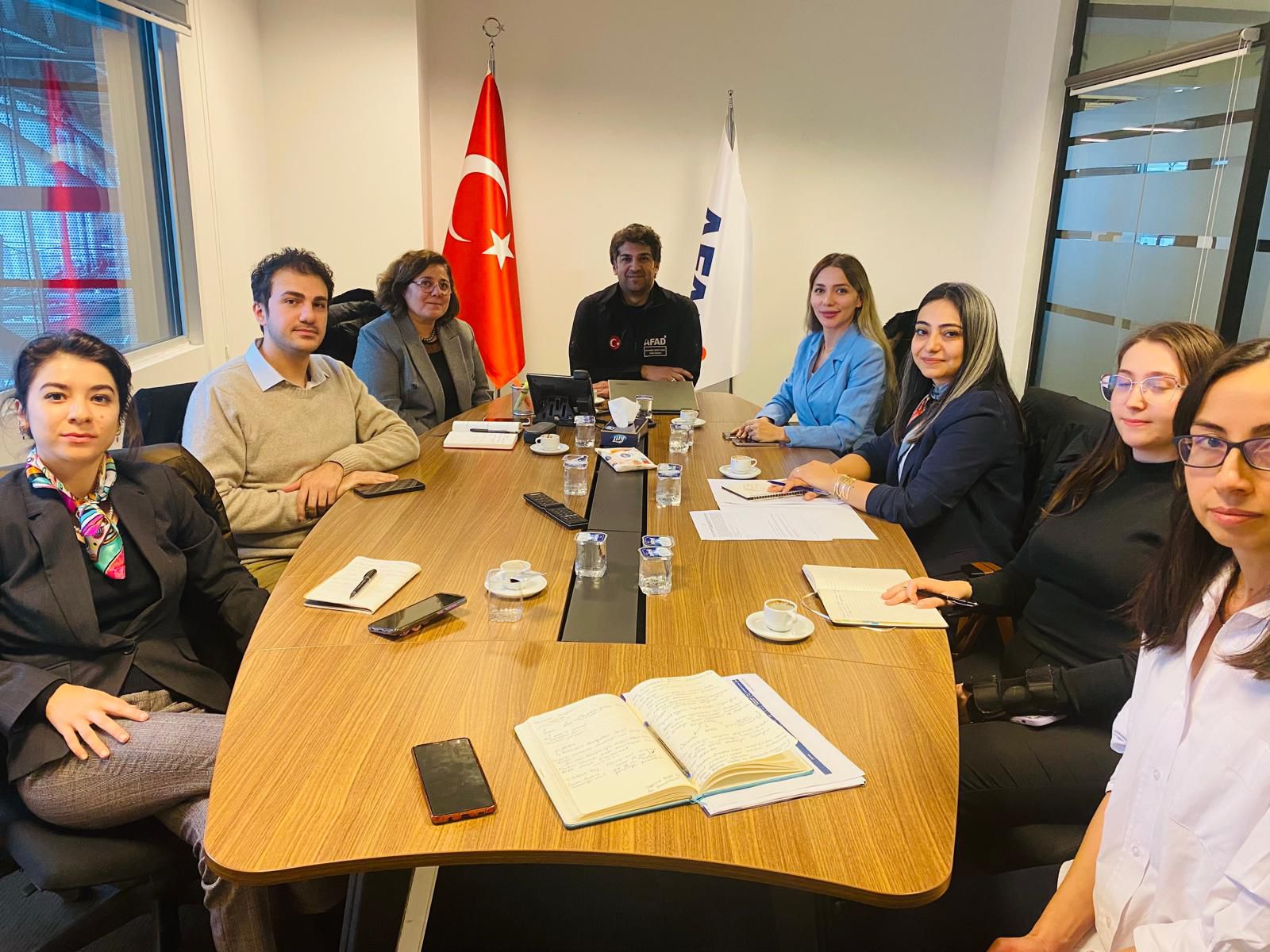 ASBÜ Yabancı Diller Fakültesi Hocaları, öğrencileri ve Dış İlişkiler Daire Başkanı Muhammet Maruf Yaman toplantı öncesi masada fotoğraf çektiriyorlar.