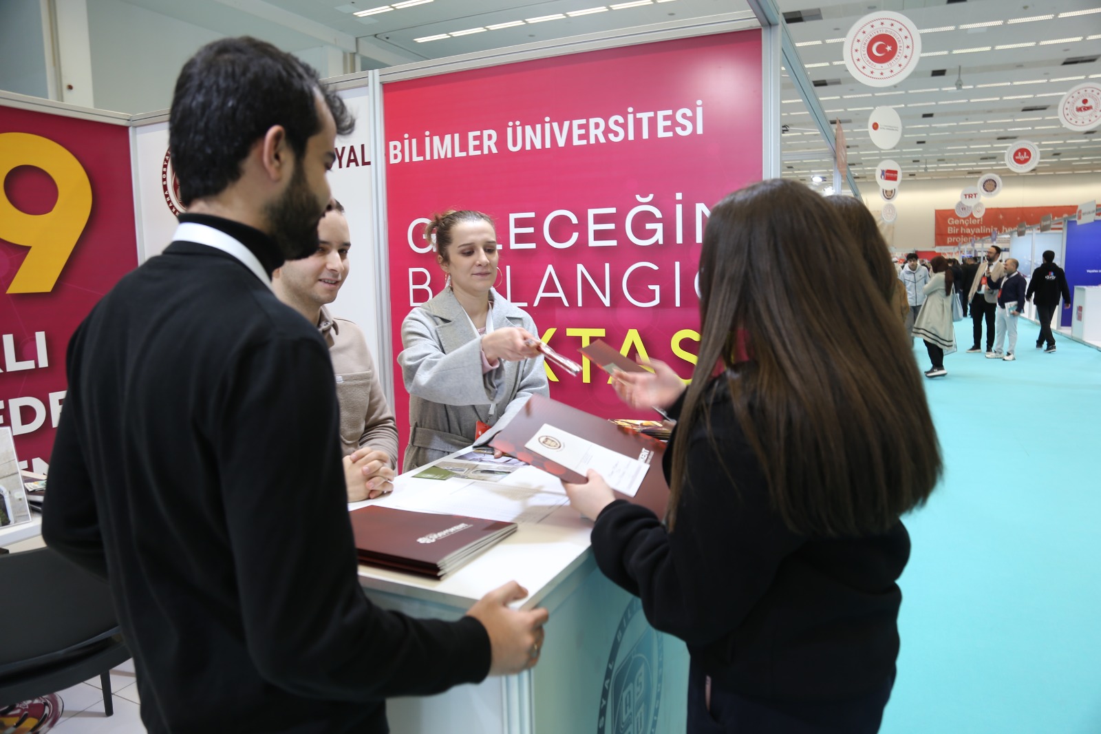 Asbü Memuru Merve Demirkol ve diğer Asbü görevlileri Asbü standına gelen kişilere yardımcı oluyorlar.
