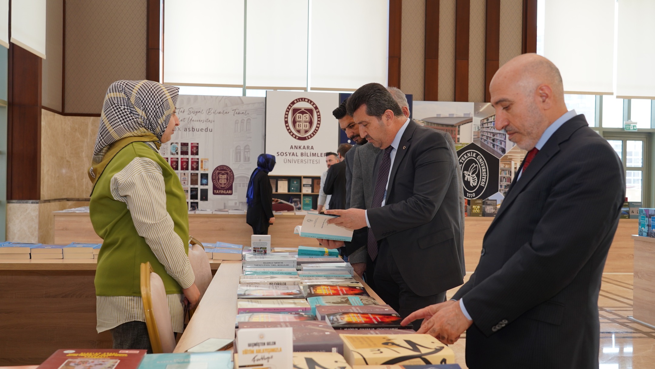 ASBÜ Rektörü Prof. Dr. Musa Kazım ARICAN ve ASBÜ Genel Sekreteri Saim DURMUŞ fuardaki standlarda kitapları inceliyorlar.