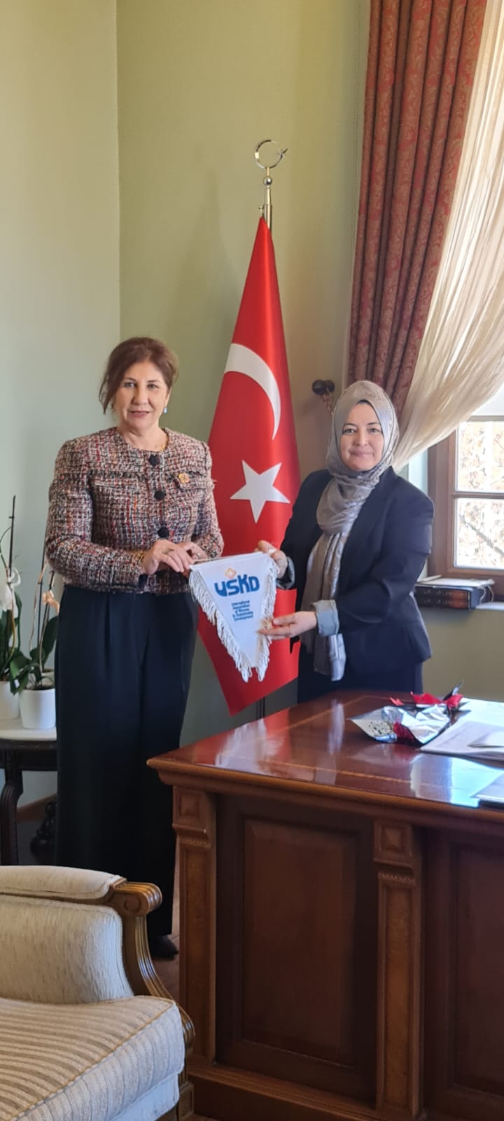 Rektör Yardımcısı Prof. Dr. Münire Kevser Baş ve USKD Başkanı Ayla Alkan birbirlerine hediye sunuyorlar