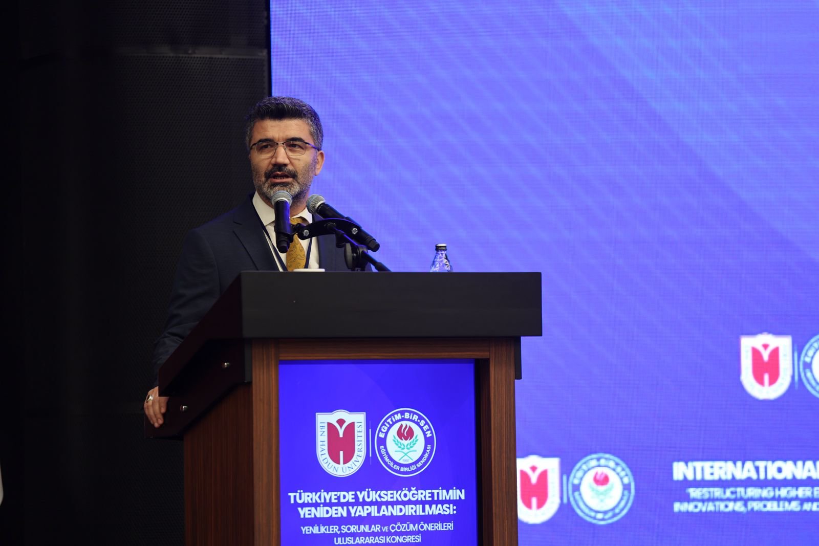 kürsüde konuşuyor